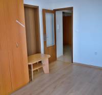 Interior of a 3-room apartment with a wooden wardrobe and open doors.