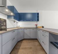A kitchen in a 2-room apartment with light furniture and dark blue cabinets.