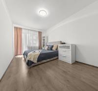Bright bedroom with a bed and a dresser in a 2-room apartment.