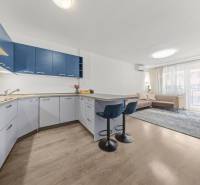 Kitchen with living area and bar stools in a 2-room apartment.