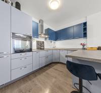 A kitchen in a 2-room apartment with modern appliances and bar stools.