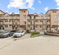 Apartment building on Dona Sandtner Street in Pezinok with parking spaces in front of the building.