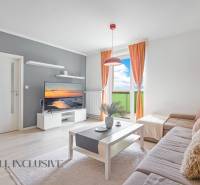 A bright living room in a two-room apartment with a balcony and a comfortable sofa.
