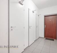A hallway with four doors and modern tiles in a 2-room apartment.