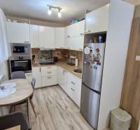 A kitchen in a 3-room apartment, light kitchen unit with equipment, wooden floor.
