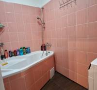 A bathroom with a bathtub and orange tiles in a 3-room apartment.