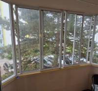 Enclosed balcony with glazing in a 3-room apartment, view of the surrounding street.