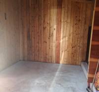 Wooden paneling and concrete floor in the cabin in Tužina.