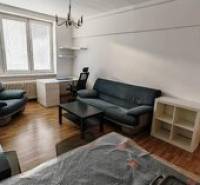 Living room in a two-room apartment with a sofa and windows with a view.