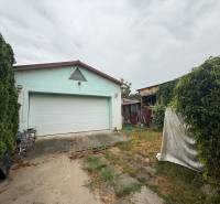 Garage and yard of a family house in Ludanice with greenery and a driveway.