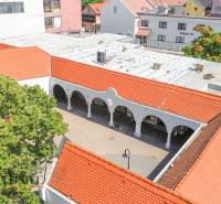 Commercial premises in Dunajská Streda with arches and red roofs near the development.