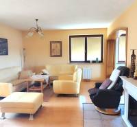 Living room of a family house with a fireplace, candles, and comfortable seating.