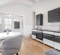A kitchen in a family house with modern equipment, a white table, and glass doors.