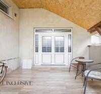 The exterior of a family house in Selice with a bicycle, table, and chairs.