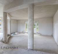 Interior of a family house with concrete columns and large windows.