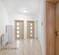 Interior of a family house with wooden doors, laminate flooring, and white walls.