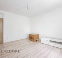 Living room in a family house with wooden doors and white furniture.