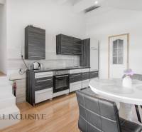 A kitchen in a family house with dark furniture and a white table with decoration.