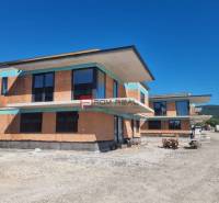 A new building with modern architecture under construction in Dubová, surrounded by spacious natural surroundings.