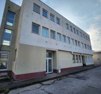 The building on Továrenská Street in Smolenice with a row of windows.