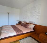 A bedroom in a two-room apartment with wooden furniture and a large bed.