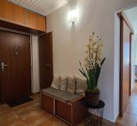 Entrance hallway in a 2-room apartment with wooden furniture and floral decoration.