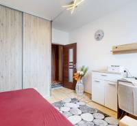 A bedroom in a two-room apartment with a built-in wardrobe and a work corner.