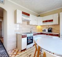 A kitchen with a dining table and appliances in a 2-room apartment, bright and cozy atmosphere.