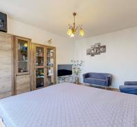 Bedroom in a 2-room apartment with a large bed, wardrobe, and chairs.