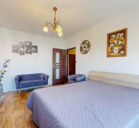 A bedroom with a double bed, two armchairs, and a wardrobe in a two-room apartment.