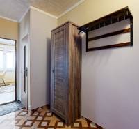 A hallway with a wooden wardrobe and a coat rack in a 2-room apartment.