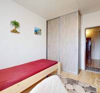 A room in a 2-room apartment with a bed, a wardrobe, a lamp, and a carpet.