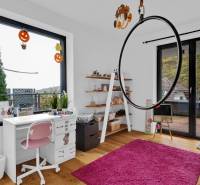 A children's room in a family house with white furniture, a pink carpet, and Halloween decorations.