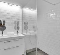 A bathroom in a family house with a sink, a shower, and ceramic tiles.