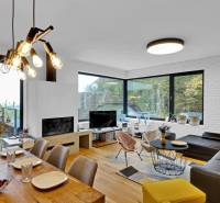 Living room of a family house with a dining table, large windows, and comfortable seating.