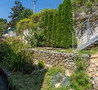 A garden with stone walls and a staircase at a family house on Sliačska Street in Bratislava.