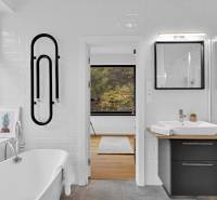 A bathroom in a family house with a bathtub, a sink, and a view of nature.