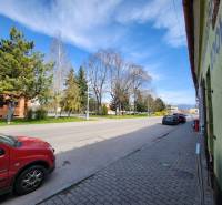 P. O. Hviezdoslav Street in Nové Mesto nad Váhom with trees and cars. Unusual properties.