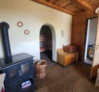 Wood-burning stove, wooden furniture, and bed in the cabin.