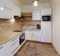 A kitchen with wooden details and appliances in a 3-room apartment, light cabinet set.