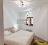 Bright bedroom with a double bed, wooden window, and a painting in a 3-room apartment.