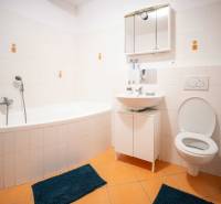 A bathroom with a bathtub, sink, and toilet in a 3-room apartment.