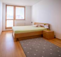 Bedroom in a 3-room apartment with a bed, window, and wooden floor.