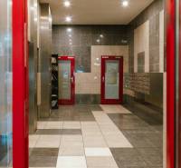 Entrance hall of a 3-room apartment with mailboxes and red doors.