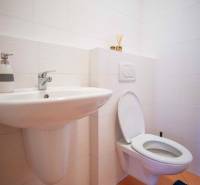 Bathroom in a 3-room apartment with a sink, toilet, and tiles in light colors.