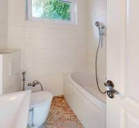 Bathroom in a cabin with a shower, bathtub, and toilet, light tiles, sink.
