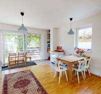 The interior of a cottage with a dining table, an armchair, and a piano, bright and cozy atmosphere.