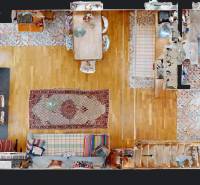 Floor plan of a cabin with carpets, wooden flooring, and a dining table in the center of the room.