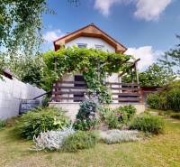 A cottage in Stupava, an orchardist, surrounded by greenery, flowers, and a garden path.