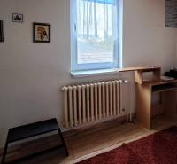 A room in a family house with a wooden floor, carpet, and furniture.
